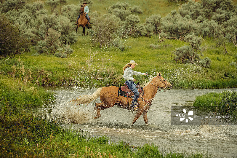 犹他州女牛仔骑马过河图片素材