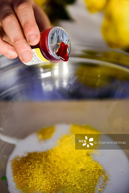 在白色胶水中加入一滴红色食用色素，放入玻璃碗中制成黏液图片素材