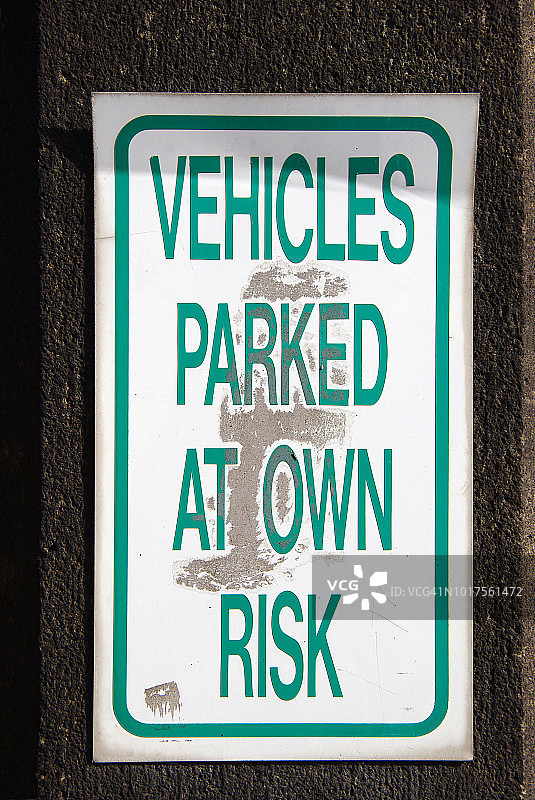 一幢建筑物外墙上的“车辆停放自行承担风险”标志图片素材