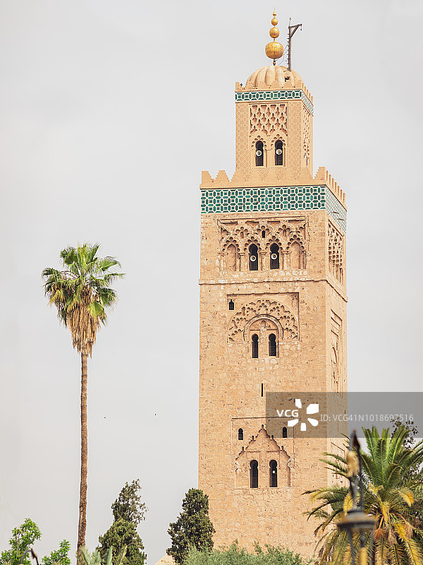 附近有棕榈树的库图比亚清真寺塔。Marrakesh-Safi、摩洛哥马拉喀什。图片素材