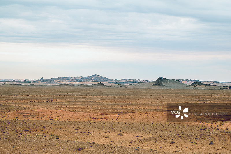 戈壁沙漠的多样景观包括参差不齐的山丘，部分被沙子覆盖，创造出迷人的颜色层。图片素材