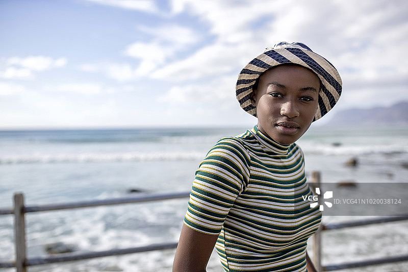 年轻女子戴着太阳帽在海上的肖像图片素材