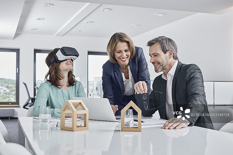 商务人士用VR眼镜、笔记本电脑和建筑模型在办公室开会图片素材