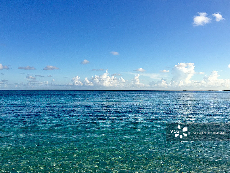 在巴哈马群岛的蓝天下，湛蓝的海水和晶莹的绿松石图片素材