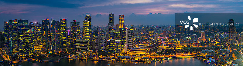 新加坡未来摩天大楼的城市景观在日落时照亮滨海湾全景图片素材