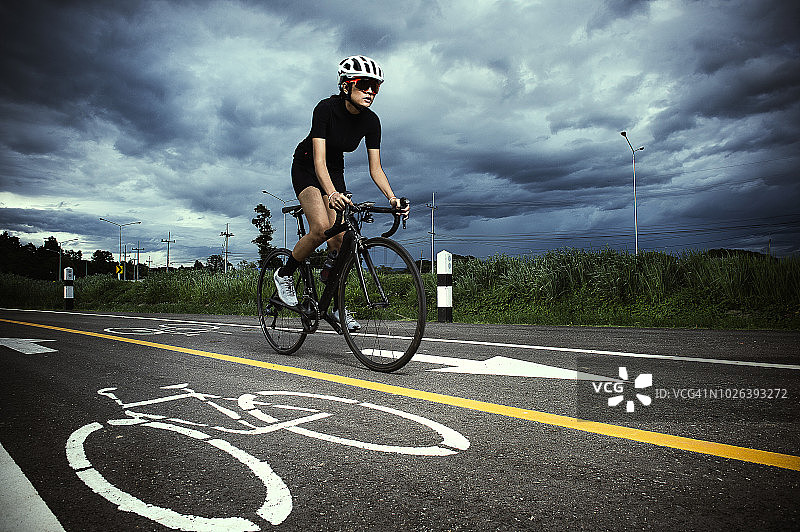 亚洲女自行车手在赛道上骑车图片素材