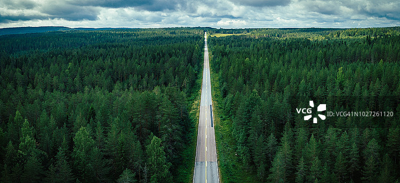 鸟瞰图一长直的乡村道路在森林中央在芬兰图片素材