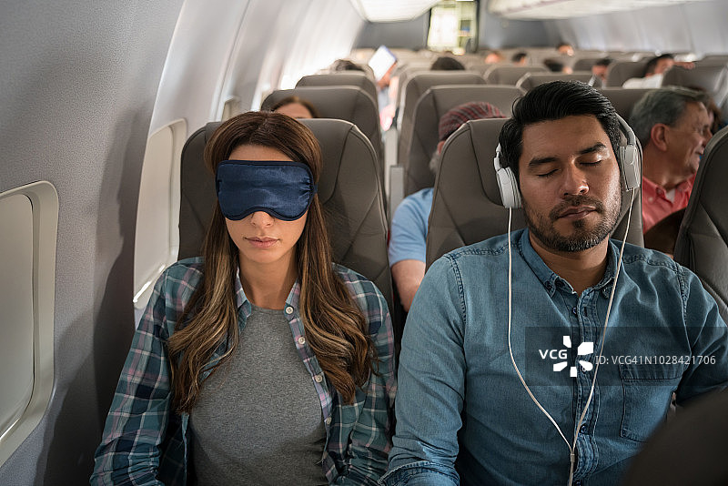 乘飞机旅行，在飞机上睡觉的人图片素材