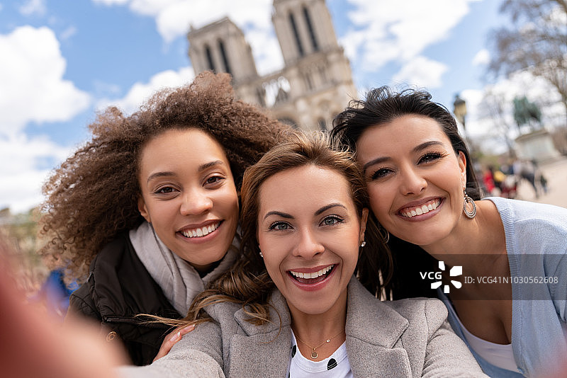 一群朋友在巴黎旅游，并在巴黎圣母院自拍图片素材
