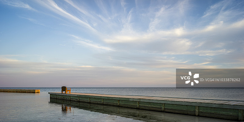 日出时码头尽头的一条木凳，面朝大海图片素材