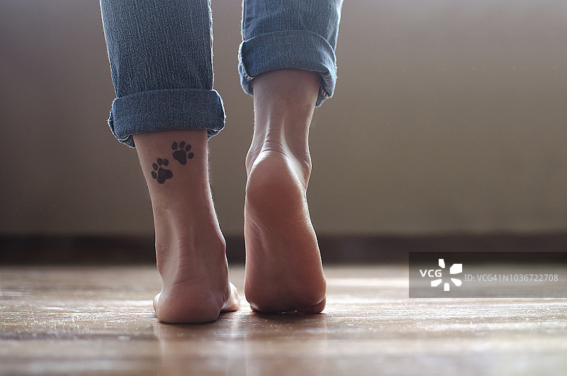 一个女孩的脚踝上有狗爪子纹身的特写图片素材
