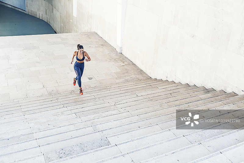 运动女人跑上城市设置的台阶图片素材