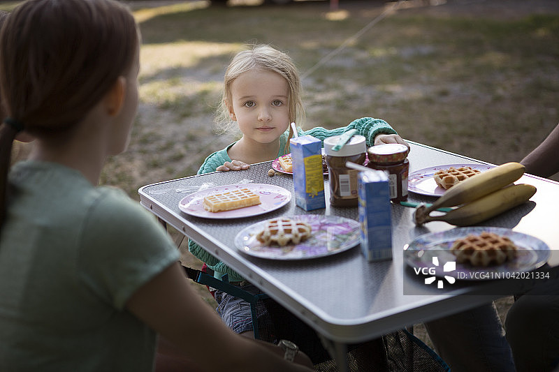 孩子们在户外的露营桌上吃早餐图片素材