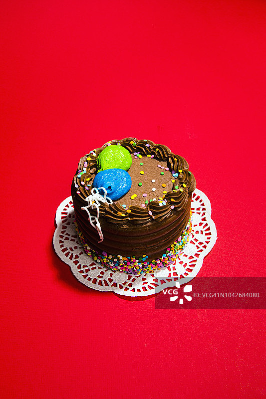 静物巧克力生日蛋糕上充满活力的红色背景图片素材