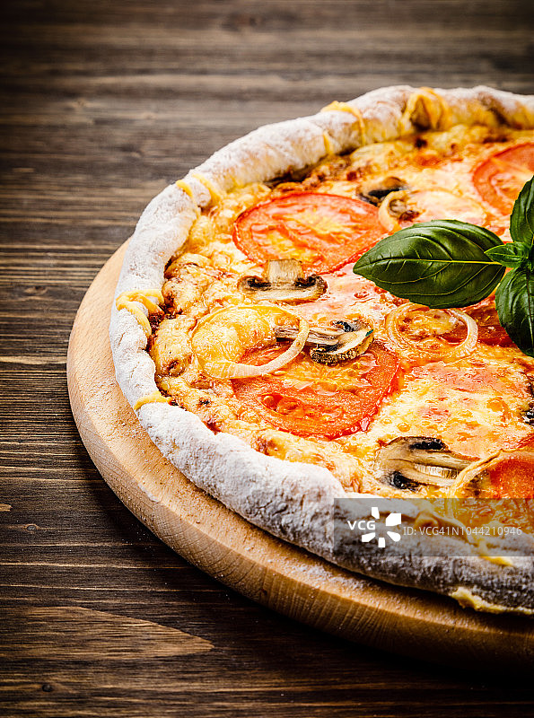 有火腿、番茄和蘑菇的披萨，背景是木头图片素材