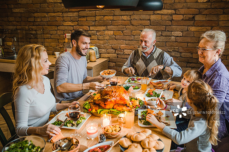 多代同堂的一家人在餐桌上享受着感恩节晚餐的快乐。图片素材