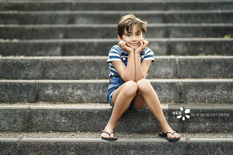 一个轻松的小女孩坐在楼梯上图片素材