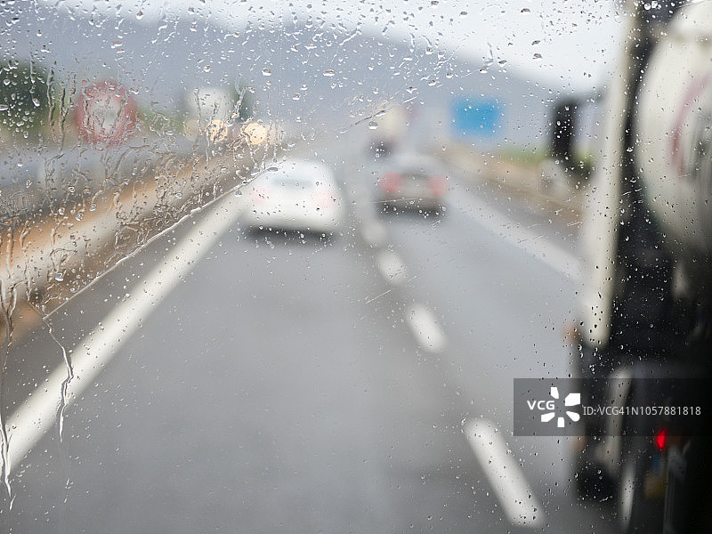 在雨天的早晨，在由几条铁轨组成的高速公路上行驶的车辆。欧洲西班牙a7 - e15高速公路图片素材