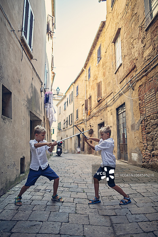 两个小男孩在意大利沃尔泰拉的街道上玩耍图片素材