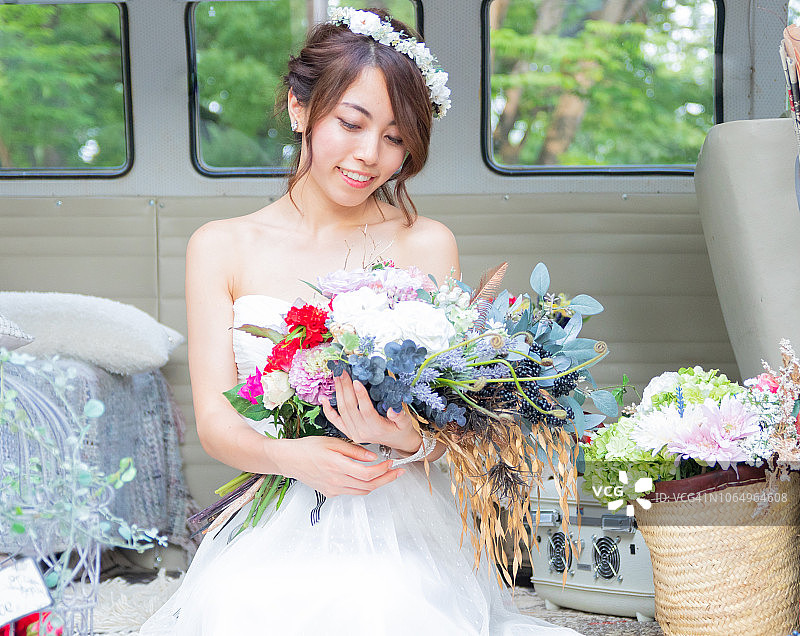 年轻的新娘看着花束图片素材