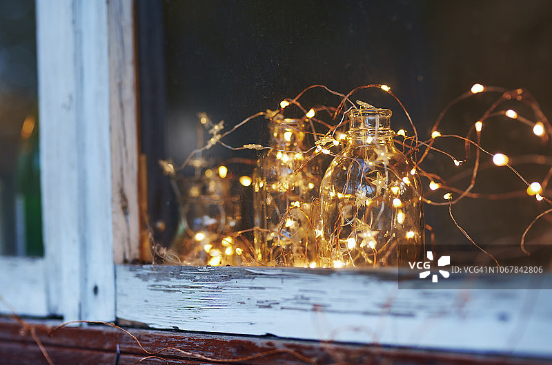 窗户上挂着圣诞彩灯的玻璃瓶图片素材