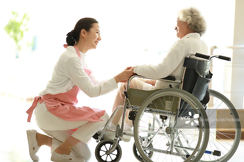 护理人员协助轮椅病人图片素材