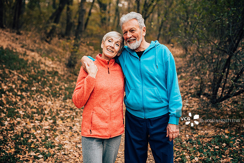 一对老年夫妇在公园里拥抱散步图片素材