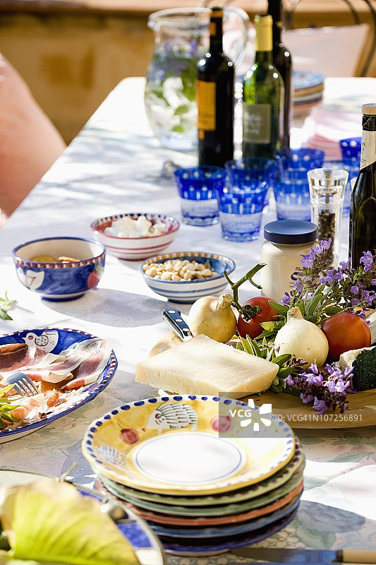 盘子，酒，新鲜的奶酪和蔬菜摆在桌上图片素材