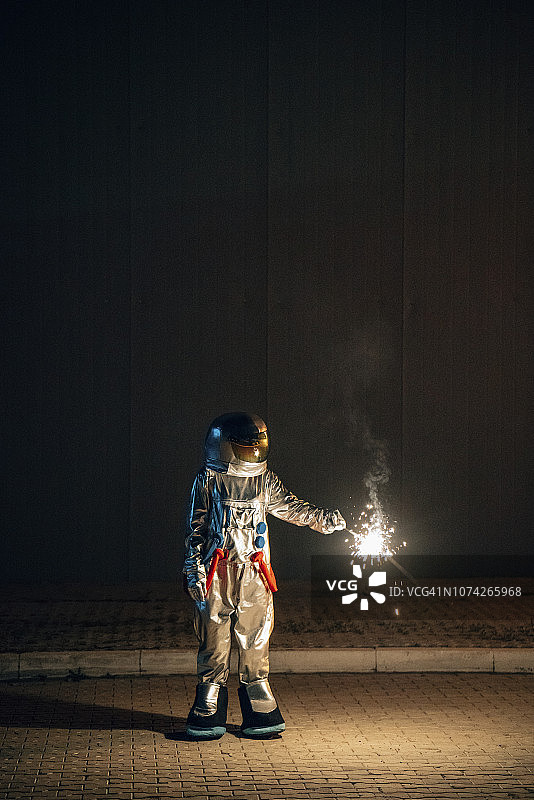 宇航员拿着烟火站在路上图片素材