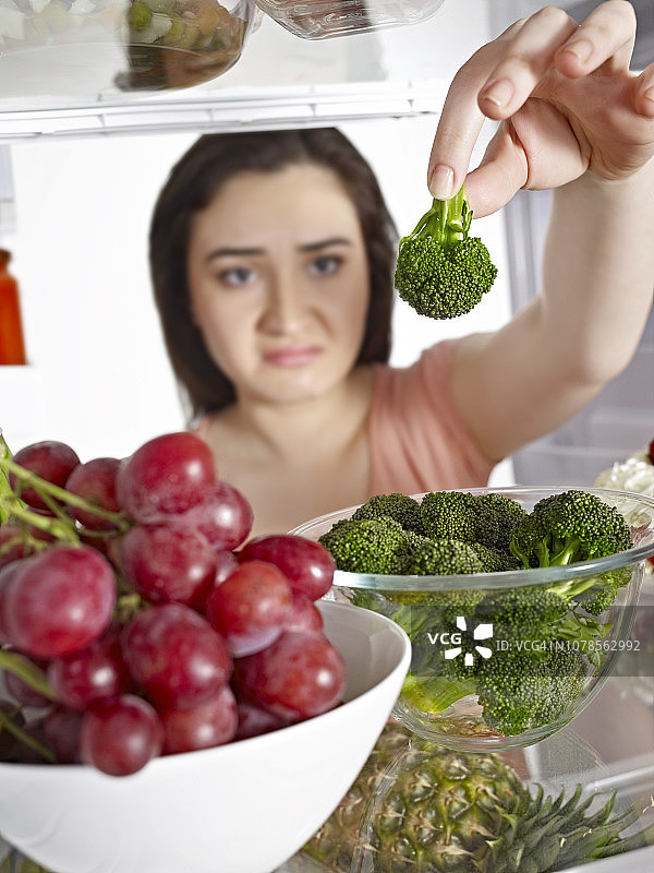 从冰箱里拿出蔬菜的女人图片素材