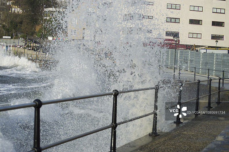 巨浪溅过人行道的栏杆图片素材