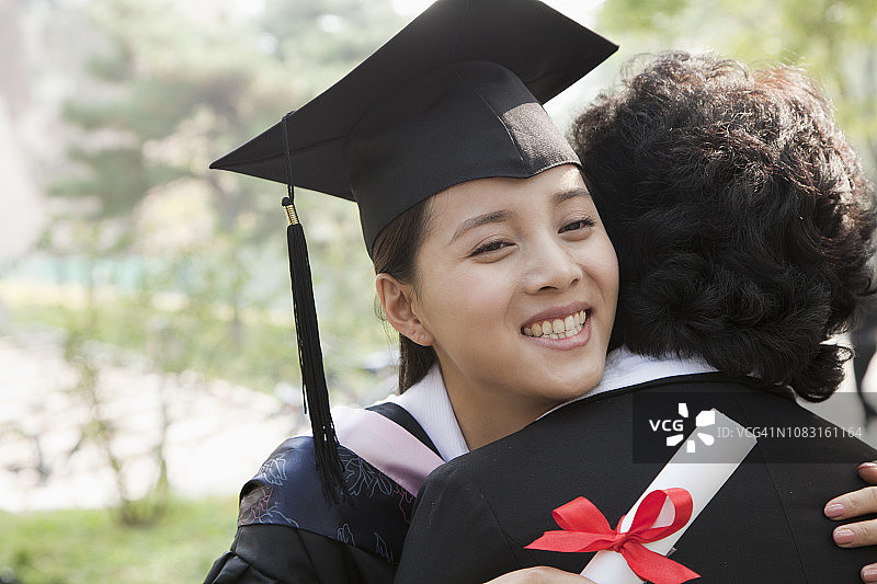 中国母亲和学生在毕业帽和长袍图片素材