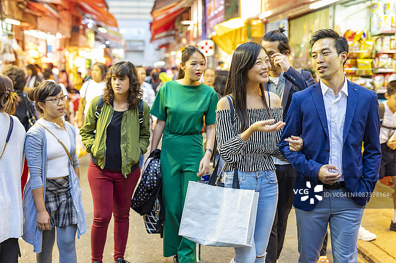 一群亚洲朋友在香港夜市购物图片素材