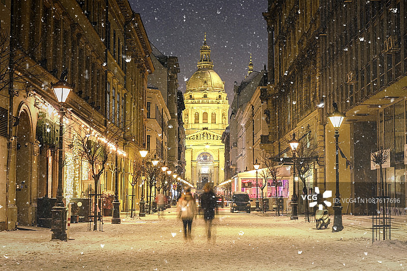 照亮布达佩斯Zrinyi街的城市景观与圣斯蒂芬大教堂在雪夜的冬季景观图片素材