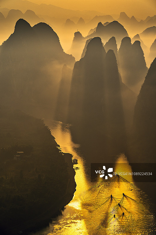 清晨的阳光穿过漓江的山丘图片素材