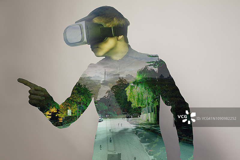 15岁男孩戴着虚拟现实眼镜玩电子游戏图片素材