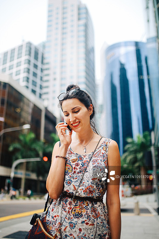年轻时尚的女人在新加坡市中心打电话图片素材
