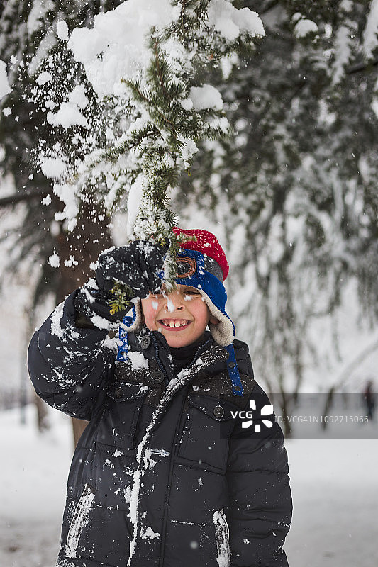 快乐的男孩在公园里玩雪图片素材
