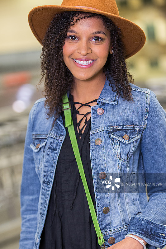 时髦的年轻混血妇女在机场微笑的肖像。图片素材