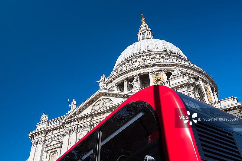 抬头看着圣保罗大教堂圆顶和一辆红色伦敦公共汽车的一部分，伦敦图片素材