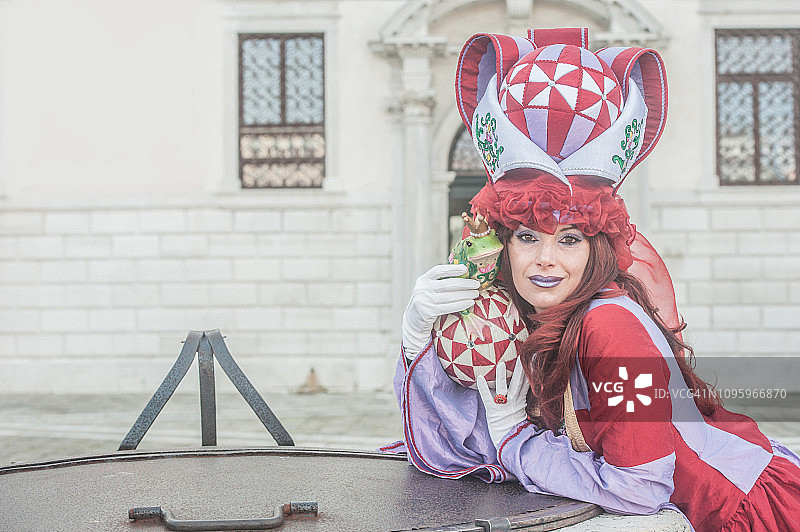 在威尼斯狂欢节上，穿着美丽童话服装的女人——公主和青蛙图片素材