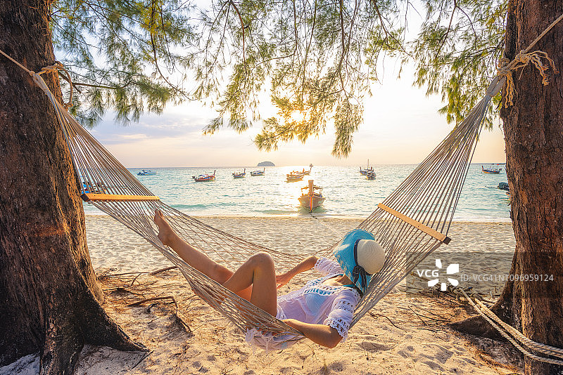 在泰国海滩上的吊床上休息的漂亮女人图片素材