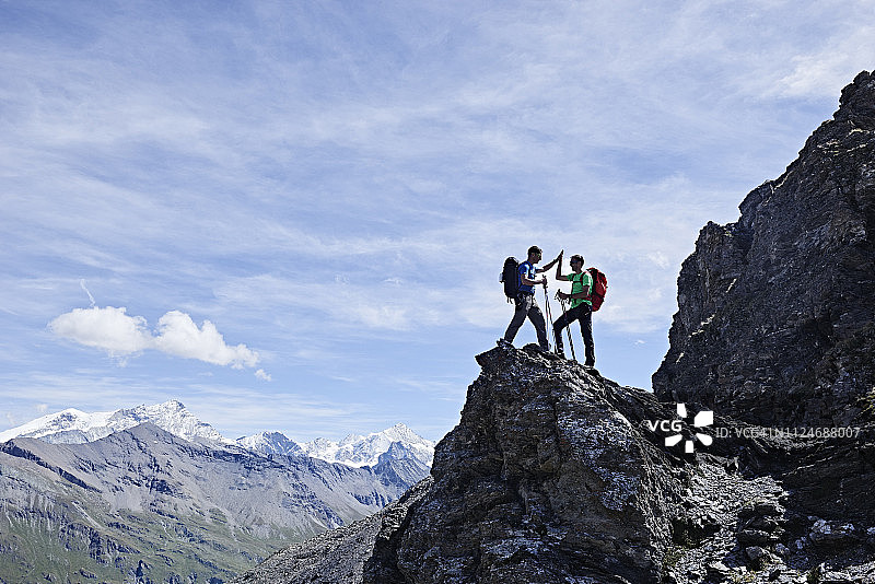 徒步旅行者在瑞士瓦莱州马特洪峰的Cervin山的岩石峰上击掌图片素材