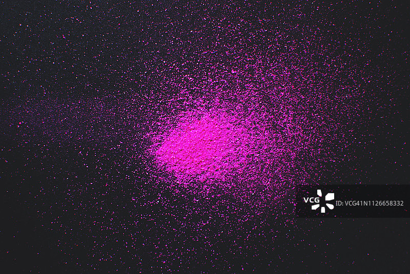 粉色粉末涂料在黑色背景下爆炸图片素材
