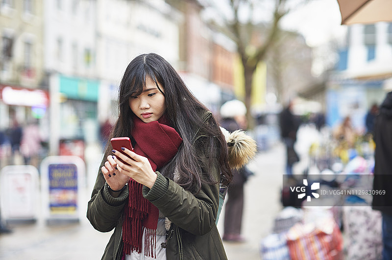 一名年轻女子在街上用智能手机图片素材