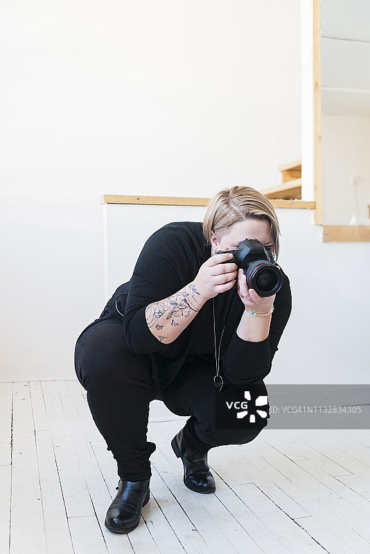 在摄影棚工作的职业女性摄影师。图片素材
