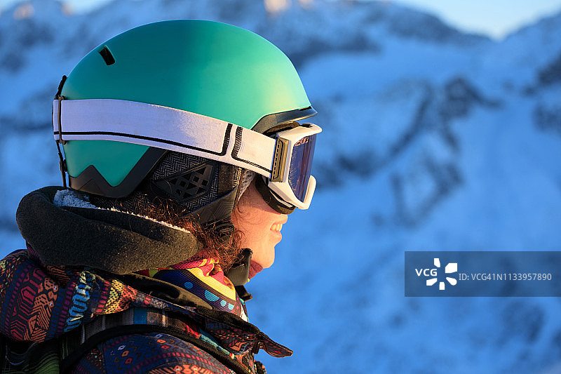 女子滑雪者喜欢在阳光明媚的滑雪胜地进行业余冬季运动。山顶上的日落。高山雪景。意大利阿尔卑斯山上的多洛米特山脉。图片素材