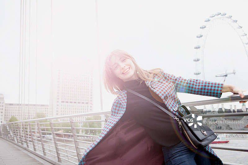 英国伦敦，年轻女游客在金禧人行桥上荡秋千图片素材