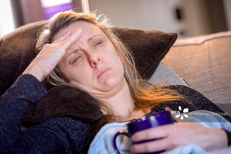 年轻成年妇女因感冒、发烧、头晕、高烧和头痛等症状在家生病图片素材