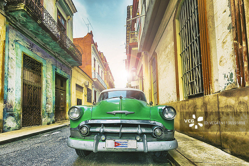 老式的绿色老爷车穿过古巴哈瓦那老城图片素材
